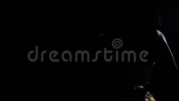 一位年轻女子在黑暗中跳舞的剪影4k视频的预览图
