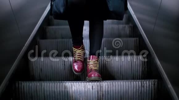 一个穿着勃艮第鞋爬扶梯女孩的腿的特写镜头视频的预览图