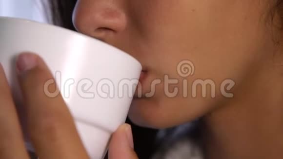 嘴唇薄的女士捧着白杯抿着茶微笑着视频的预览图