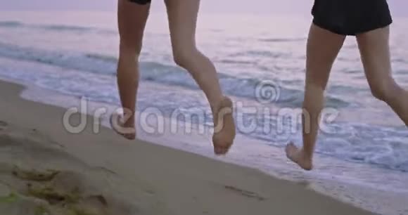 早晨海滩边两位女士在早晨一起跑步腿在水中的细节视频的预览图