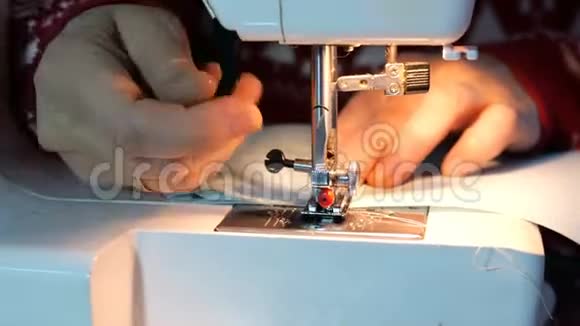 裁剪工艺女性手使用缝纫机与内置灯的光这将是纺织服装视频的预览图