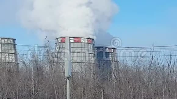 工业区有大管道的冷却塔有一股白色的浓烟在一个大城市的火电站工作视频的预览图