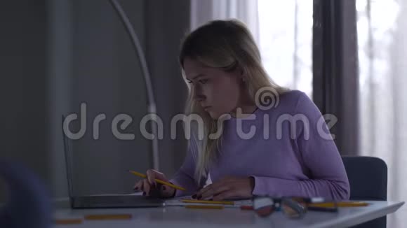 年轻的白人女人看着笔记本电脑屏幕绘制蓝图漂亮的职业建筑师视频的预览图