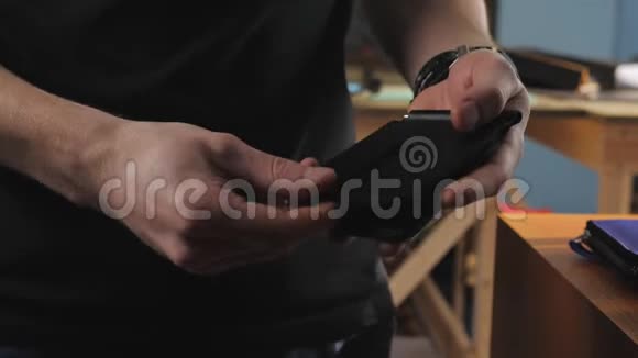 男人的特写镜头展示了一个带夹子的皮包用来存钱视频的预览图