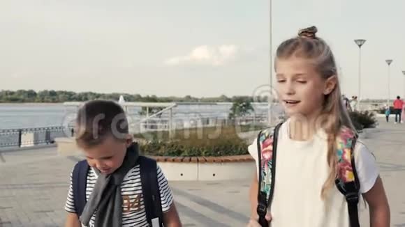 带着背包的男孩和女孩走路说话小学教育友谊童年交流和人视频的预览图