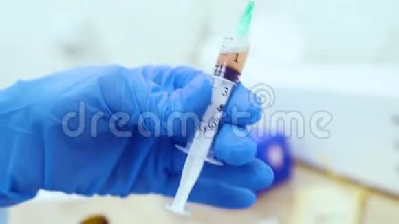 医生手里拿着一个注射器里面有血浆或者用一个特写注射用于头发再生和皮肤再生视频的预览图