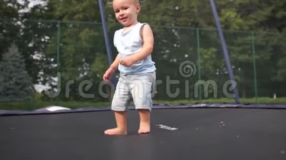 一个小男孩在蹦床上缓慢地跳着视频的预览图