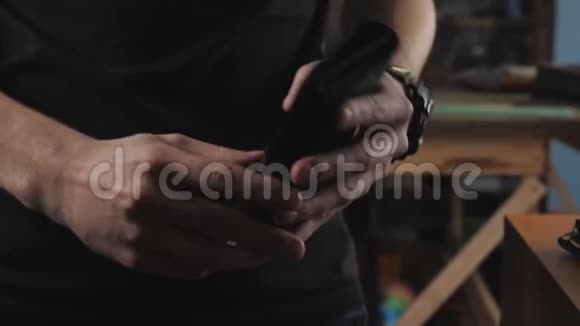 一个男人展示一个钱包是手工制作的在一个坦纳的车间特写视频的预览图