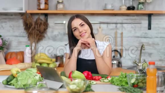 在烹饪新鲜可口的蔬菜时微笑的女性家庭主妇在厨房摆姿势视频的预览图