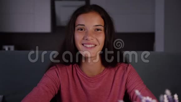 穿着运动衫带着微笑黑发的女孩在视频聊天视频的预览图