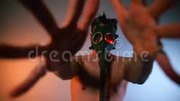 一个戴着防毒面具的年轻人正在俱乐部的狂欢舞会上跳舞视频的预览图