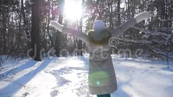 镜头跟随着无法辨认的女孩在雪林中奔跑快乐的女人享受冬天的时光和自由视频的预览图
