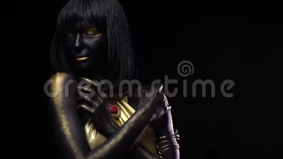 一个有着黑色和金色的化妆和有爪子的身体艺术的女人正在摆姿势视频的预览图
