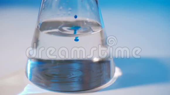 在实验室里一位科学家进行化学实验将蓝色液体倒入烧瓶中概念视频的预览图