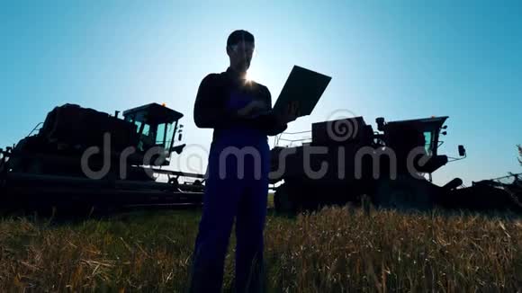 农业机器和一名男性农学家站在附近视频的预览图