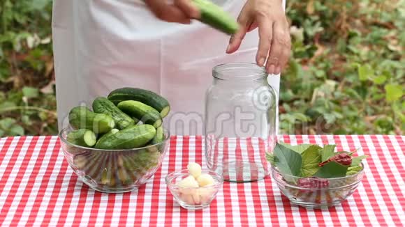 女厨师把黄瓜放进空玻璃罐里保存视频的预览图