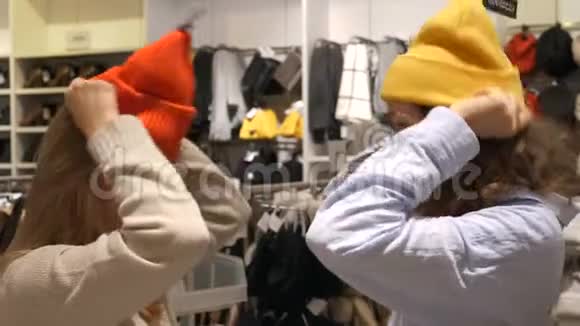 在城市购物中心的商店里女人们尝试戴帽子享受休闲时光视频的预览图