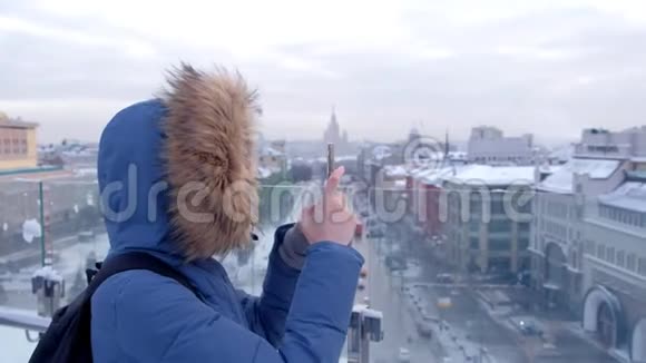 女游客在大城市的楼顶打电话拍摄视频视频的预览图