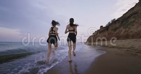 令人惊叹的海滩景色两位漂亮的女士在早上一起跑步呼吸新鲜空气享受海景慢慢慢慢视频的预览图