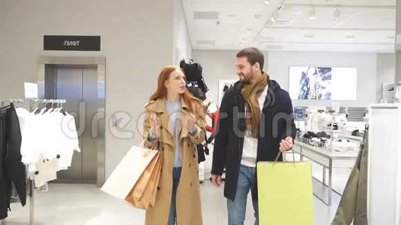 现代情侣在商场购物手里拿着包互相看着视频的预览图
