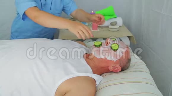 一个女性美容师把保湿面膜贴在男人脸上视频的预览图