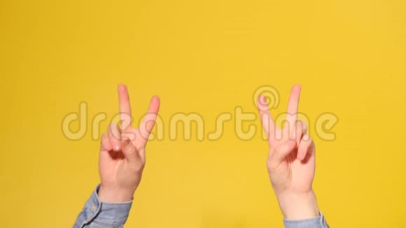男子手显示胜利标志手指与黄色背景隔离视频的预览图