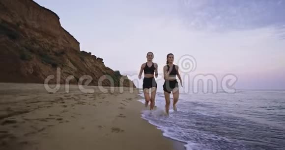 漂亮的女士早上在海滩上奋力奔跑背景景色令人惊叹视频的预览图