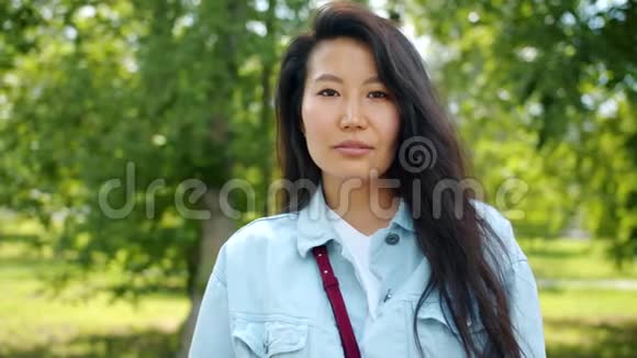 秋天公园里快乐的亚洲女人微笑着站在户外视频的预览图