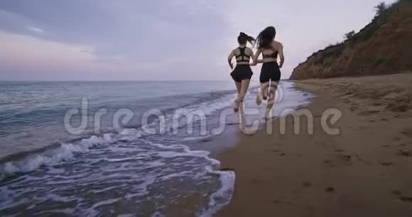 健康的生活方式理念两位年轻的女士早晨在海滩上奔跑带着令人惊叹的风景视频的预览图