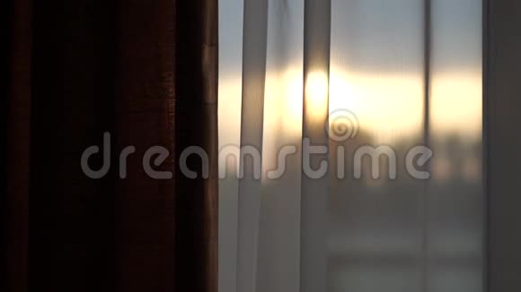 窗外日落白色窗帘上慢动作视频的预览图