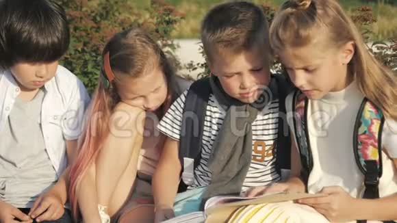 四个孩子在公园里读一本书玩得很开心视频的预览图