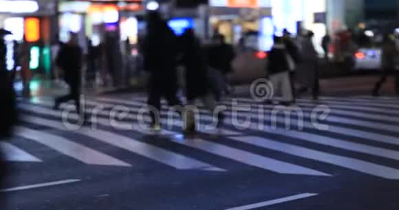 在新宿东京的十字路口行走的人夜间雨天手持视频的预览图