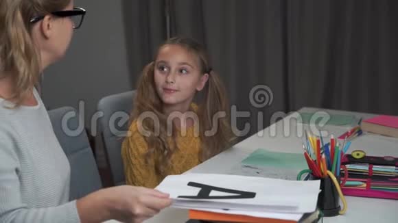 一个白人女孩学习字母的肖像她聪明的年轻母亲戴着眼镜带着字母卡片视频的预览图