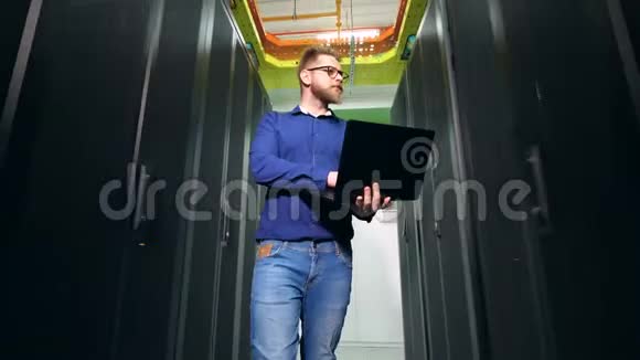 年轻的成人系统管理员手提电脑站在数据中心视频的预览图