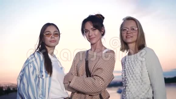 三个快乐的年轻休闲女人站着微笑着对着镜头视频的预览图