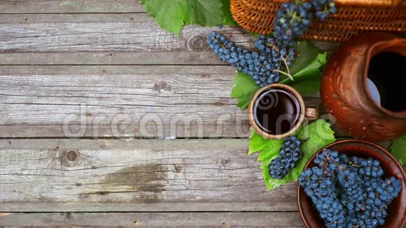篮子和碗与葡萄旁边的罐子和杯子与葡萄酒站在乡村木材酿酒背景顶部视图视频的预览图