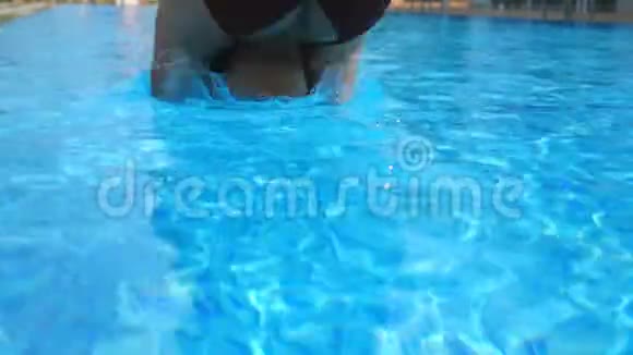 活跃的年轻女人在游泳池里潜水和泼水女士在热带度假胜地放松穿着泳衣的女人视频的预览图
