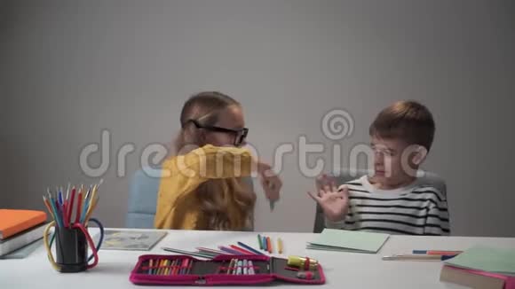 戴眼镜的白人女孩和她的男同学用五颜六色的钢笔打架成年女人过来安抚他们视频的预览图