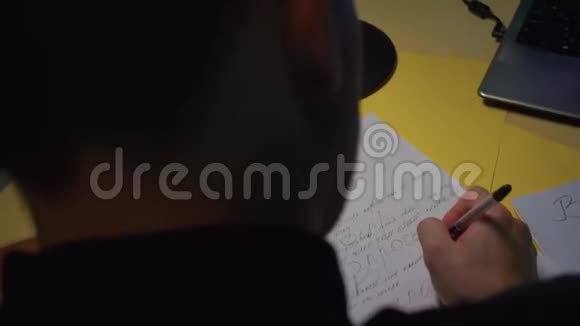 特写镜头他把笔记写得很疯狂笔在纸上坐在桌子旁视频的预览图
