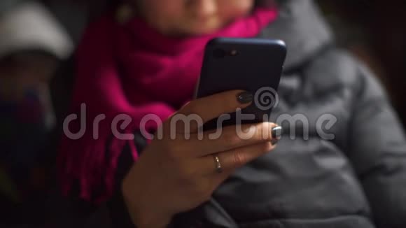 晚上公共汽车上一个女人手中的智能手机特写视频的预览图
