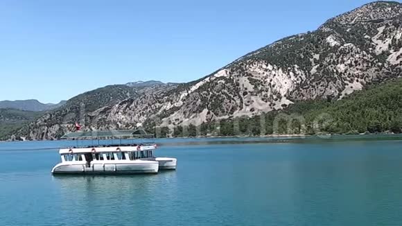 绿色峡谷绿松石水上的白色游船视频的预览图
