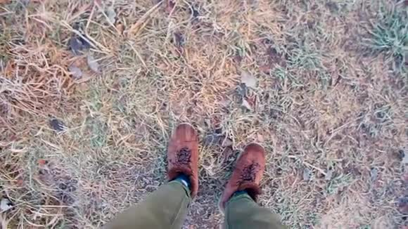 穿着冬靴在森林道路上行走的森林人的脚视频的预览图