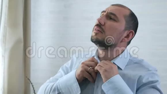 男人双手扣着一件白色衬衫留胡子的人早上穿衣服上班体胸毛视频的预览图