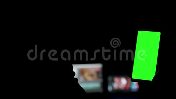 绿色屏幕智能手机在黑暗的房间视频的预览图
