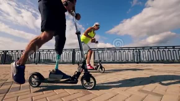 有假肢的男人一起骑滑板车视频的预览图