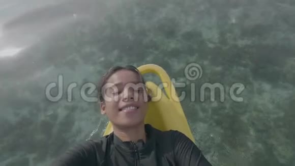 自拍视频微笑的女人放松在桨板航行在海洋视频的预览图