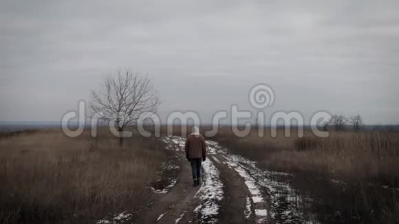 一个孤独的人走在冬天的田野上视频的预览图