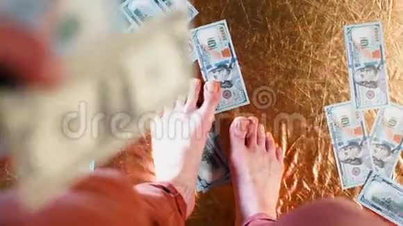 一个商人走在100美元的钞票上视频的预览图
