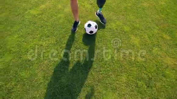 带着残疾人踢足球踢足球的绿色草坪视频的预览图