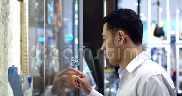 年轻英俊的穆斯林男子在商店橱窗里视频的预览图